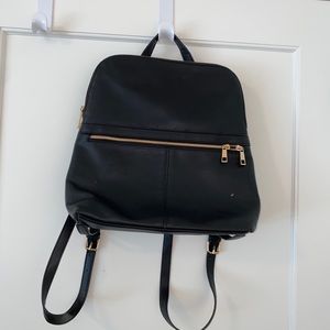Black bag with backpack straps. Gold zippers